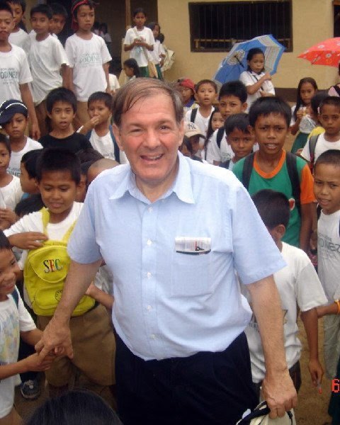 Professor Albert Santoli surrounded by schoolchildren in the Philippines