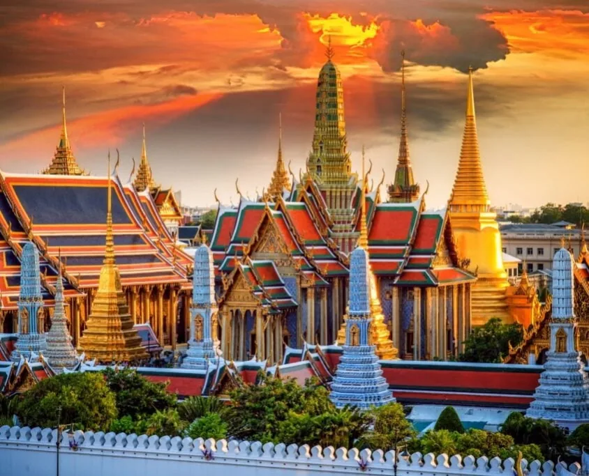 Spires and tiled roofs of the Grand Palace in Bangkok, Thailand, at sunset