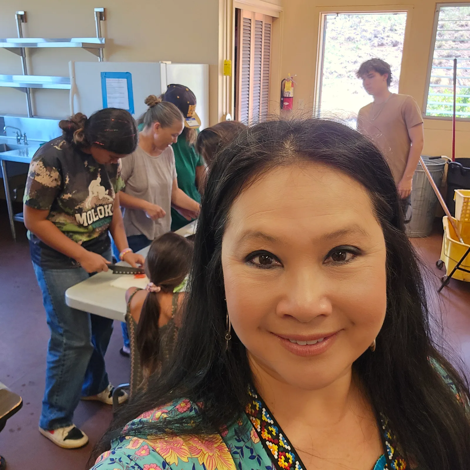 Dr. Lansing in the camp kitchen as campers and volunteers prepare food together