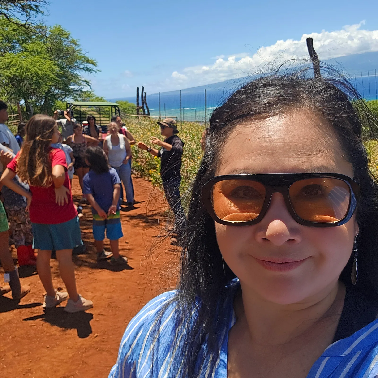 Dr. Lansing with campers on a red-dirt trail above the ocean while a guide leads a lesson on caring for the land