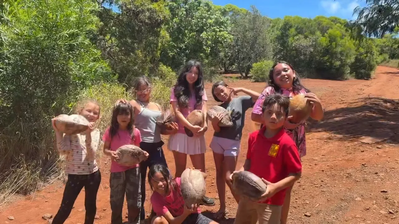 Campers hold up the coconuts they harvested